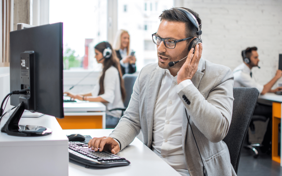 A man sits at his desk at a 911 center using the NICE Inform Elite platform.